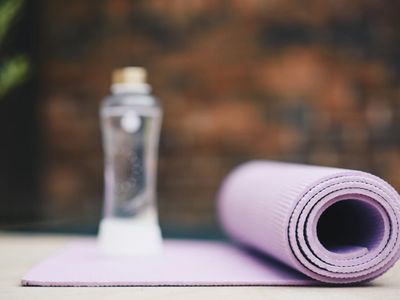 A water bottle and a rolled up yoga mat.