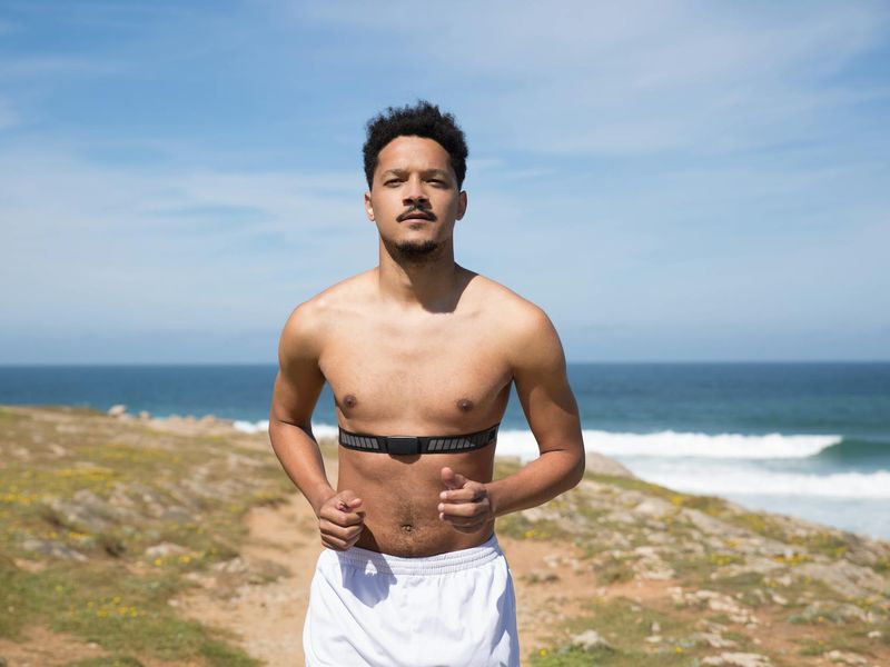 Person mid-stride while jogging in a green city park.